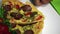 Appetizing pizza is on a plate. A woman is folding napkins.