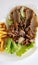 Appetizing plate featuring kebab, green lettuce and french fries