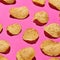 Appetizing potato chips in rows on pink background