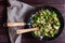 Appetizing sauteed brussels sprouts and champignons in skillet with wood turner