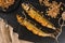Appetizing smoked fishes with sawdust and burlap texture on slate stone background. Mediterranean food, herring fish, seafood