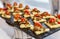 Appetizing snacks on the buffet table at the event. Canapes with meat and cherry tomatoes. Close-up