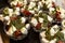 Appetizing snacks on the buffet table at the event. Tomato salad with feta cheese and pesto. Close-up