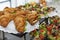 Appetizing snacks on the buffet table. Filled croissants and portioned salads. Business meetings and celebrations. Selective focus