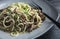 Appetizing spaghetti with meat and herbs on a plate on a table in a restaurant. Close-up