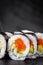 Appetizing sushi roll futomaki with cucumber and salmon on a black stone plate