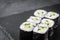 Appetizing sushi roll maki with cucumber on a black stone plate