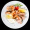 Appetizing Tuna steak with tomato, lemon and sauce in a white pl