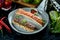 Appetizing Turkish lamb lula kebab with tomato tartare and red sauce, served in a gray plate. Dark marble background. Barbecue