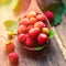 Appetizing wild strawberry in a wooden spoon on the table. Berry in the morning light, a healthy breakfast. Diet Concept