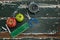 Apple, alarm clock, duster, scissors and chalk on wooden table