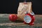 Apple, alarm clock and lunch bag on wooden table