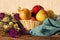 Apple apples in a woven vase blue towel wild flowers bouquet on a wooden table close-up