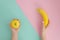 Apple or banana Creative trendy concept on bright split color background. woman hand holding yellow small apple and