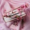 Apple blossoms and vintage book arranged on bright pink background. Flat lay