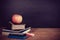 Apple, Books and Chalks with Blackboard Background