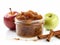 Apple butter in a jar with cinnamon sticks and apples