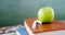 Apple and chalk on book stack