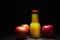 Apple cider vinegar in a glass jug, fresh apples, dark wooden ba