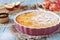 Apple clafoutis pie with praline in ceramic dish for sweet dessert and fresh apples