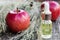 Apple essential oil on a wooden table near ripe red apples. Essential oil is used to fill lamps, perfumes and in cosmetics