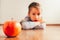 Apple in the foreground and child in the background unfocused, angry at not wanting to eat fruit. Healthy infant feeding concept