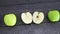 Apple halves on wooden table next to whole apples and camera panning