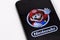 Apple iPhone 6s with Super Mario Bros figure character from Super Mario video game console developed by Nintendo