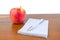 An apple notepad and a lie on the table.