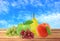 Apple, pear, peach and grape on wooden table over blurred blue s