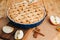 Apple pie in blue form on a light wooden background on a wooden tray. Ready pie