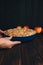 Apple pie in blue form in man& x27;s hands on a dark wooden background. Ready pie