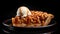 Apple pie with caramel topped with a scoop of vanilla ice cream