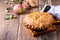 Apple pie in cast iron skillet on rustic wooden table
