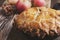 Apple pie in cast iron skillet on rustic wooden table