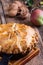 Apple pie in cast iron skillet on rustic wooden table