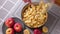 Apple pie preparation series - woman pours chopped apples into a baking dish