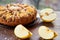 Apple pie with quince, poppy seeds, raisins and sesame on the dark plate decorated with sliced fresh apples on wooden brown table