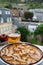 Apple products of Normandy, homemade baked apple cake and cider drink and houses of Etretat village on background, Normandy,