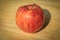 Apple shadows stretching out onto a wooden cutting board. Nice and ripe and ready to be eaten.