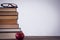 Apple by stack of book with eyeglass at table