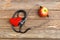 Apple, stethoscope and heart on wooden background
