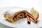 Apple strudel with cinnamon on white plate, product photography for patisserie or bakery, sweet cake