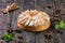 Apple tart with meringue and lime peel on a wooden stand