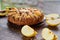 Apple tart with quince, poppy seeds, raisins and sesame on wooden brown table. Apple pie decorated with sliced fresh quince, apple