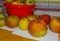 Apples from an apple tree on a wooden kitchen counter along a window in autumn