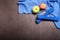 Apples, blue towel and dumbbells on dark background