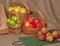 Apples of different varieties in baskets of different sizes with craft bags on burlap
