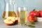 Apples, glass and jug with juice on grey background