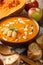 Apples pumpkin puree soup served with toasted bread closeup. vertical